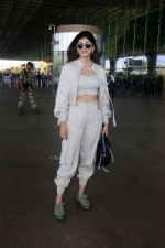 Sanjana Sanghi holding bag wearing cream colored long sleeved top and trousers and grey footwear with laces (1)_646f4089cafa6.jpg