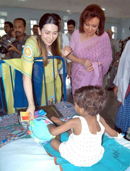 Karishma Kapoor playing with an infant at Wadia Hospital