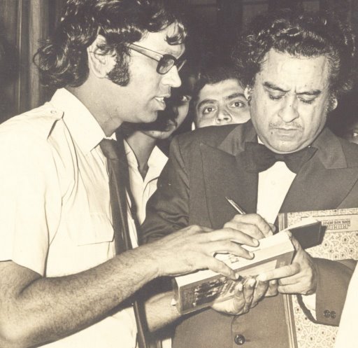 kishore signing an autograph for his fan