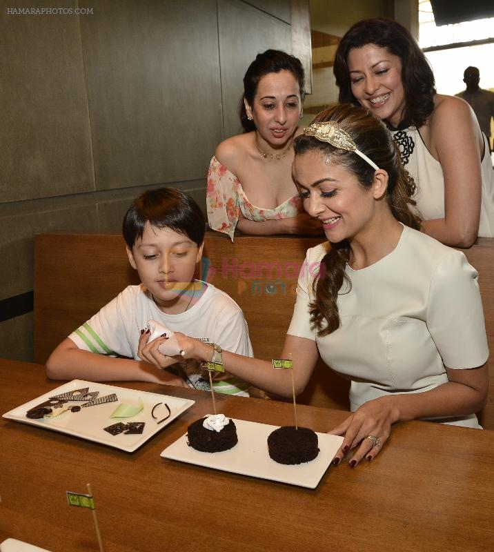 Amrita Arora showing her bakery expertise to Alesia Raut's son at the launch of Shine young 2015 at Phonix Marketcity Kurla