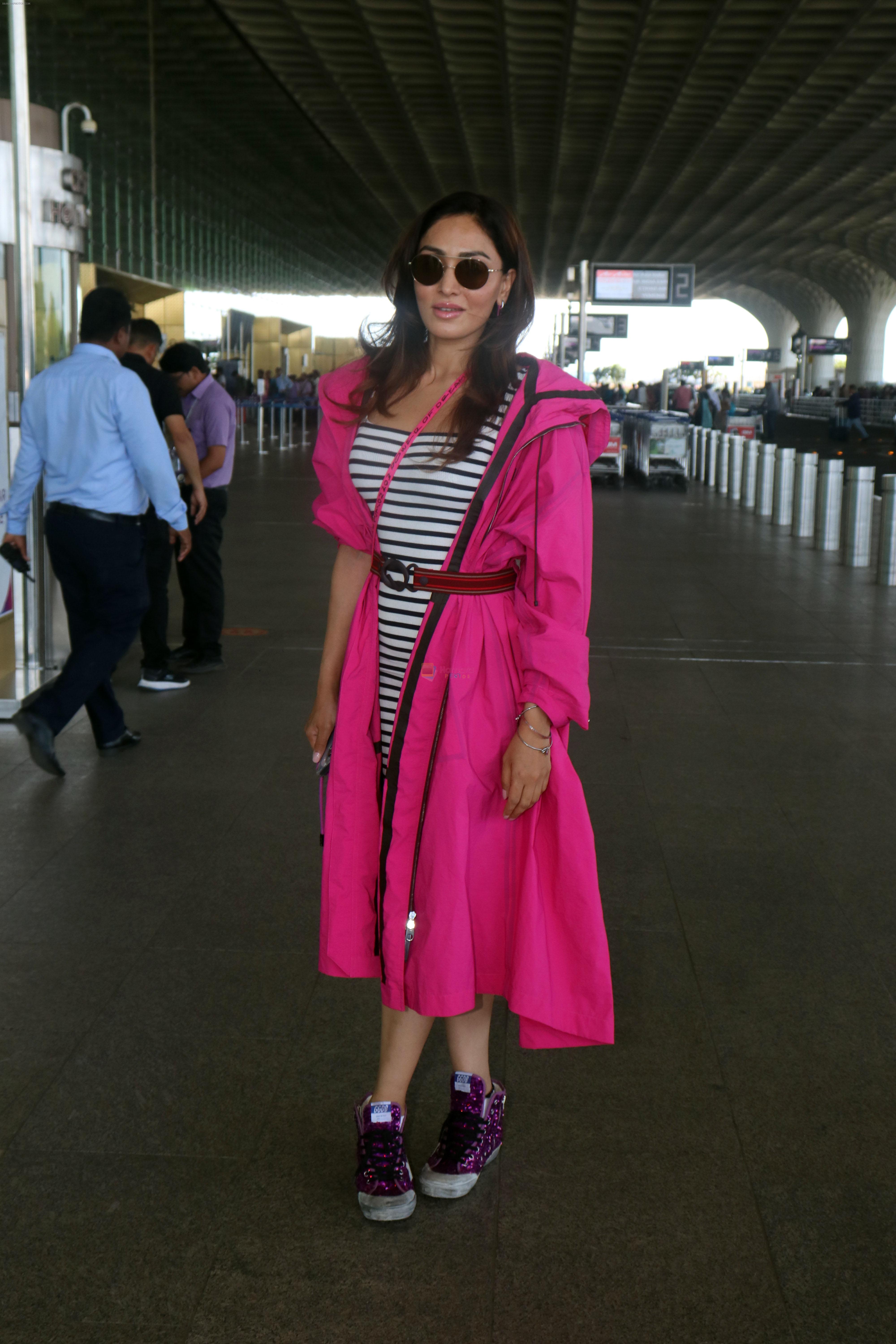 Khushali Kumar wearing a stylish pink coat and sunglasses in a pair of purple high top sneakers