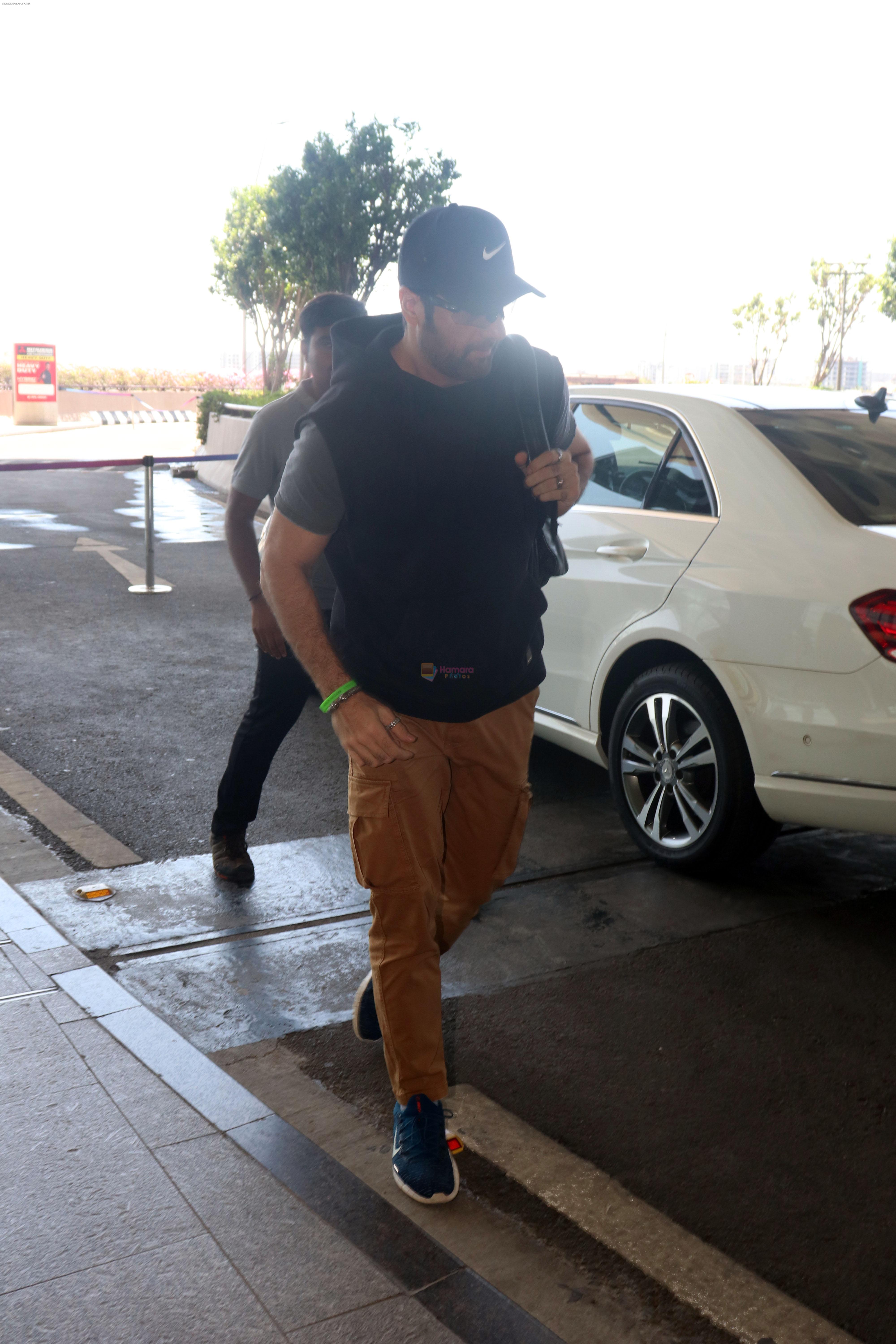 Fardeen Khan wearing sunglasses, black shirt, khaki pants, blue nike shoes and black Nike hat