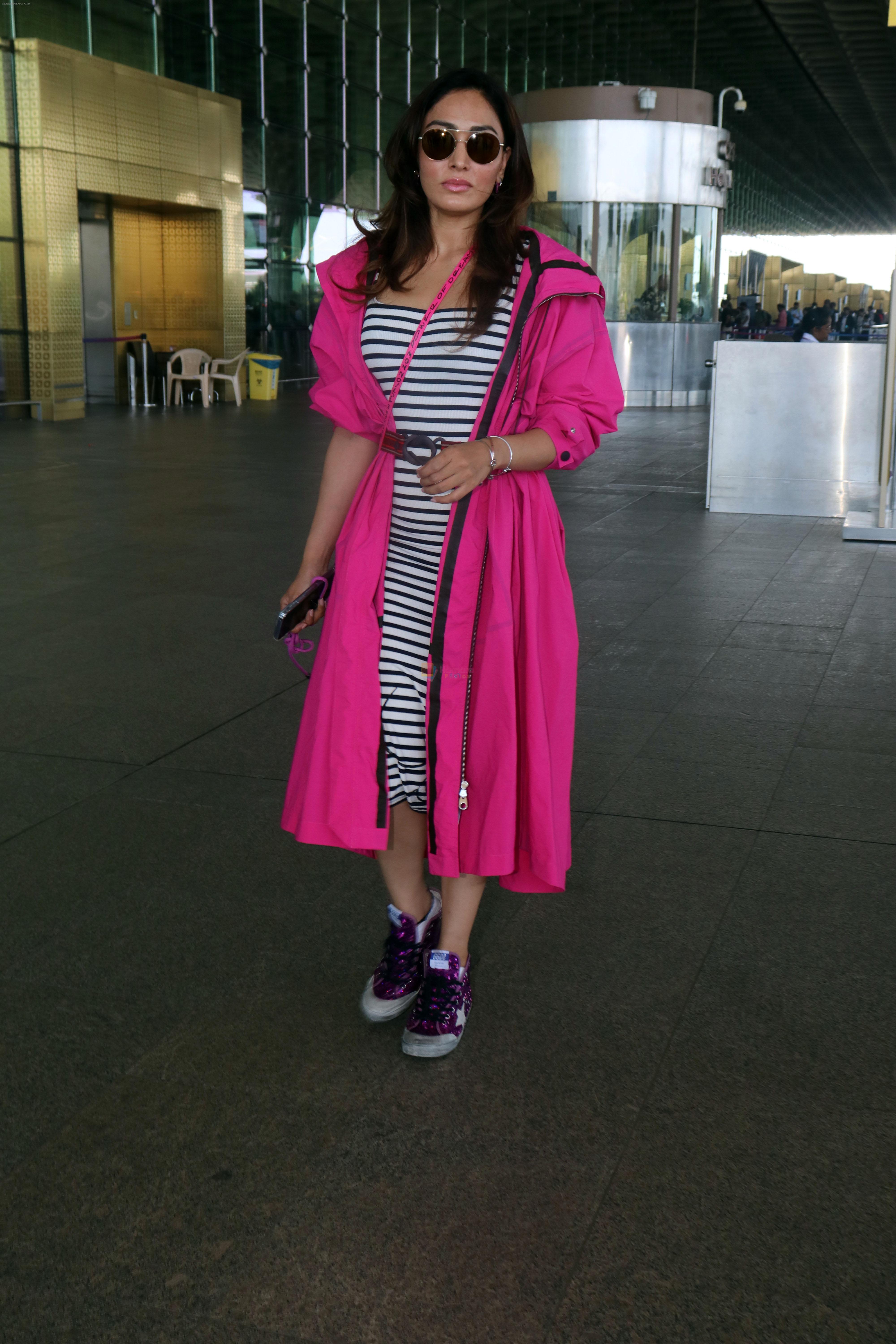 Khushali Kumar wearing a stylish pink coat and sunglasses in a pair of purple high top sneakers