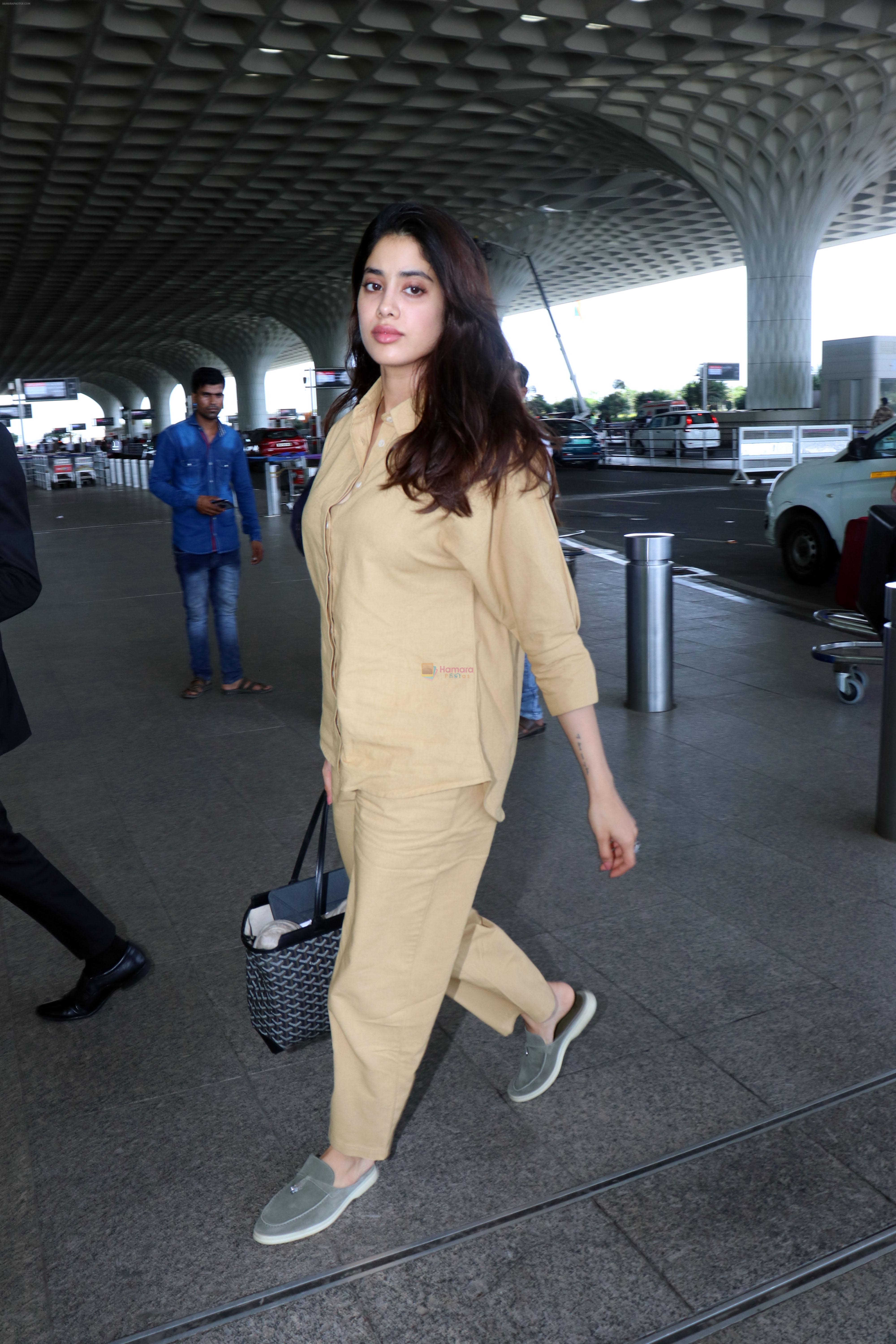 Janhvi Kapoor holding Tas Goyard Saint Louis PM Tote handbag wearing light brown shirt and wide pants and Meya light green genuine suede leather loafer shoes