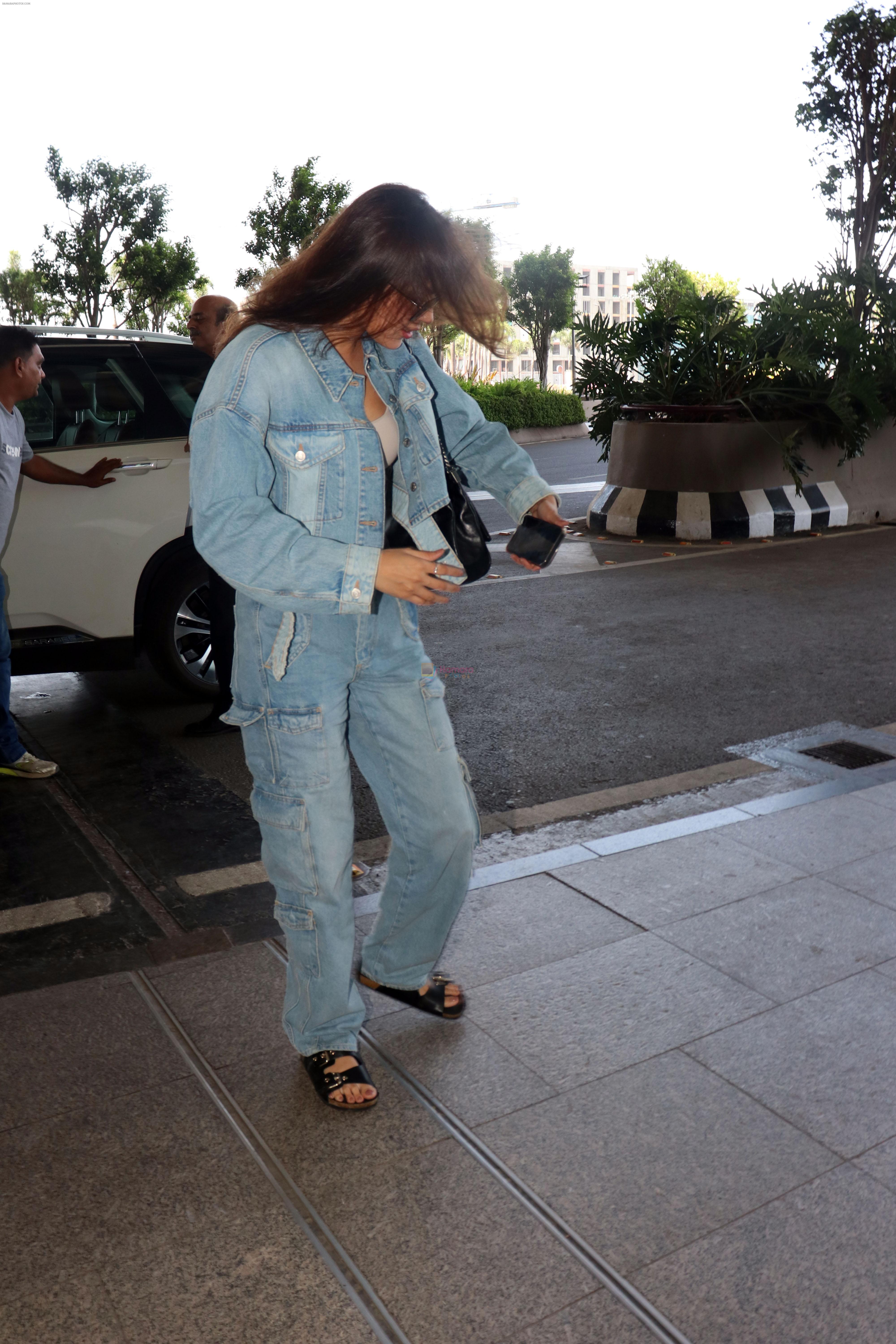 Rhea Chakraborty dressed in Jeans jacket and pant wearing dark glasses and black sandals