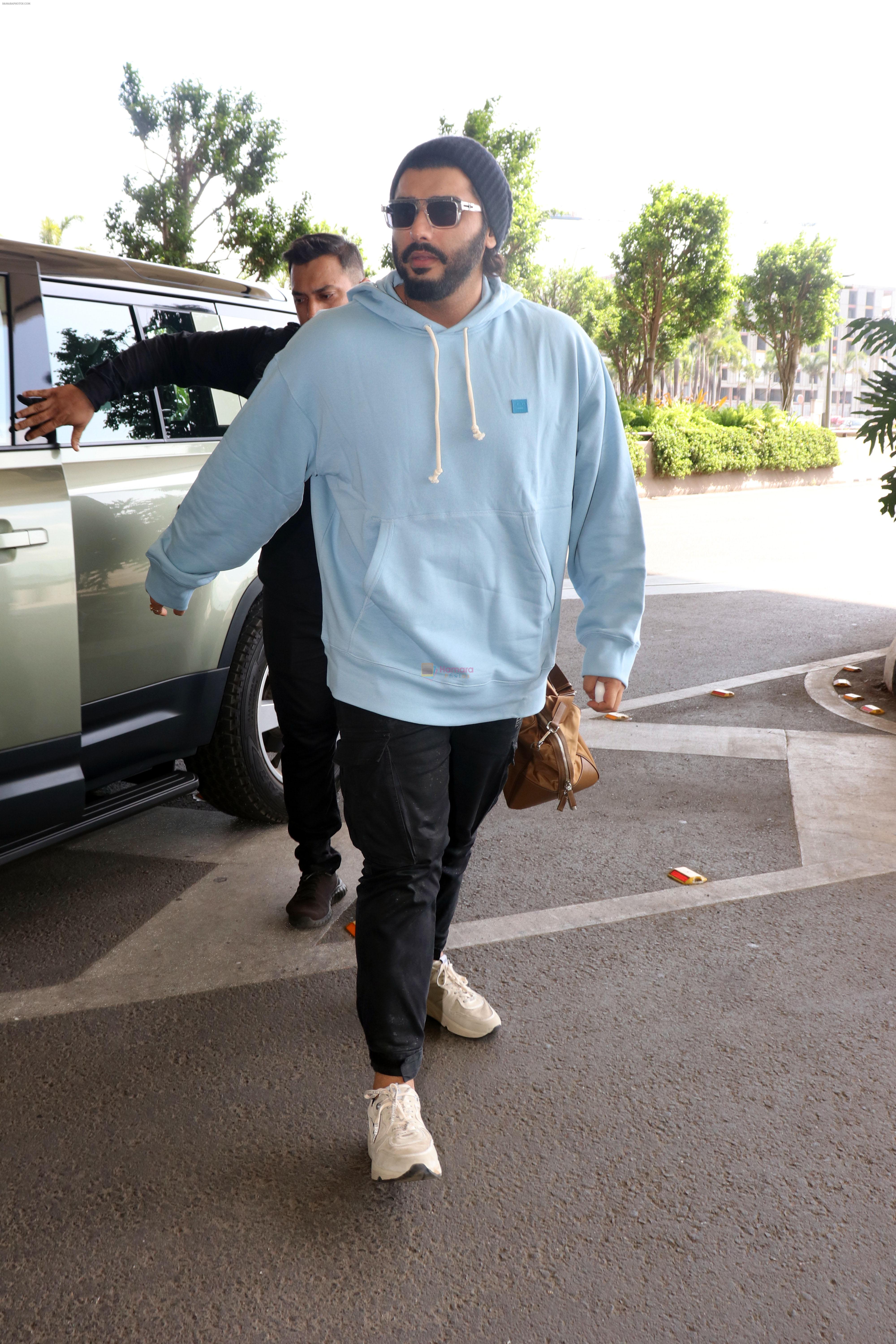 Arjun Kapoor with sunglasses on wearing Powder Blue Hooded Sweatshirt and black sweatpant, white sneakars and beanie cap