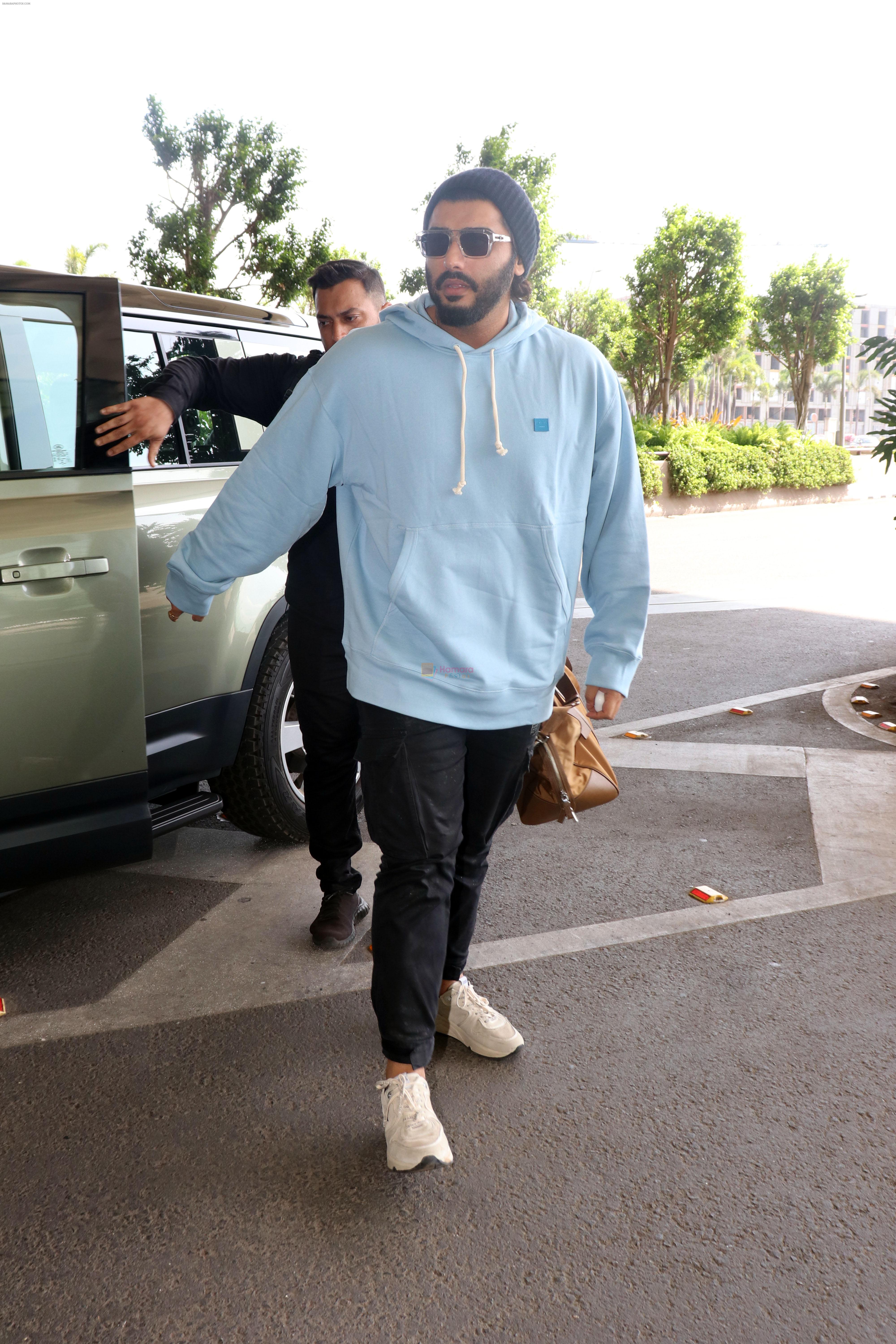 Arjun Kapoor with sunglasses on wearing Powder Blue Hooded Sweatshirt and black sweatpant, white sneakars and beanie cap