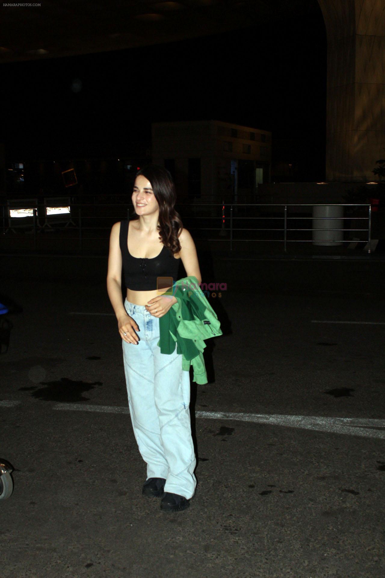Radhika Madan wearing black tank top baggy blue jeans holding green jacket