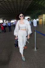 Sanjana Sanghi holding bag wearing cream colored long sleeved top and trousers and grey footwear with laces (13)_646f3eeae34d5.jpg