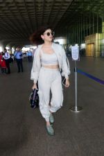Sanjana Sanghi holding bag wearing cream colored long sleeved top and trousers and grey footwear with laces (14)_646f3eee540ea.jpg