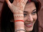 Bollywood actor Aishwarya Rai, with her hand decorated with henna, smiles during the shooting of a movie in Agra.jpg