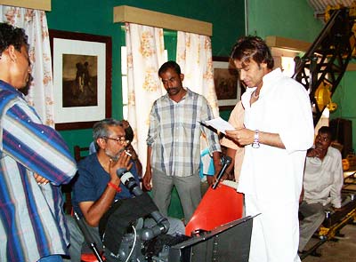 Director Prakash Jha looks on as Ajay Devgan memorises lines