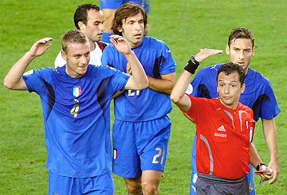 Uruguayan referee Jorge Larrionda gives a yellow card to Italian midfielder Daniele De Rossi
