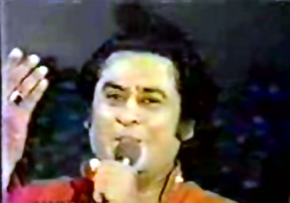 Kishore singing on a stage the Gemstone can be Clearly seen here