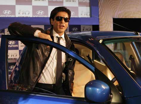 Actor Shah Rukh Khan poses with a car during its world premiere launch in New Delhi