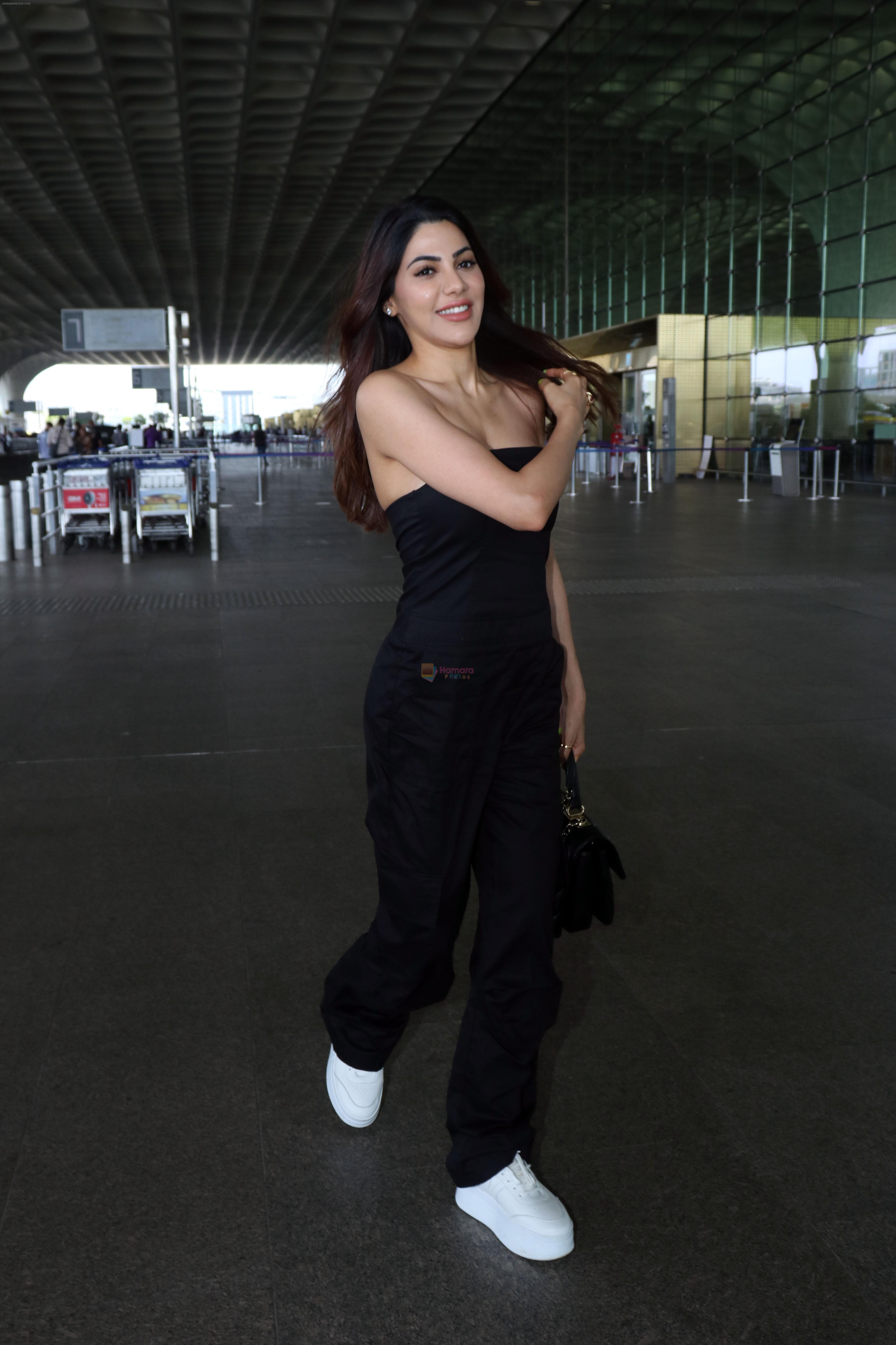 Nikki Tamboli wearing all black strapless bodycon dress, white sneakers holding Tamboli holding Chanel Black Quilted Lambskin Small Trendy Top Handle Flap Bag