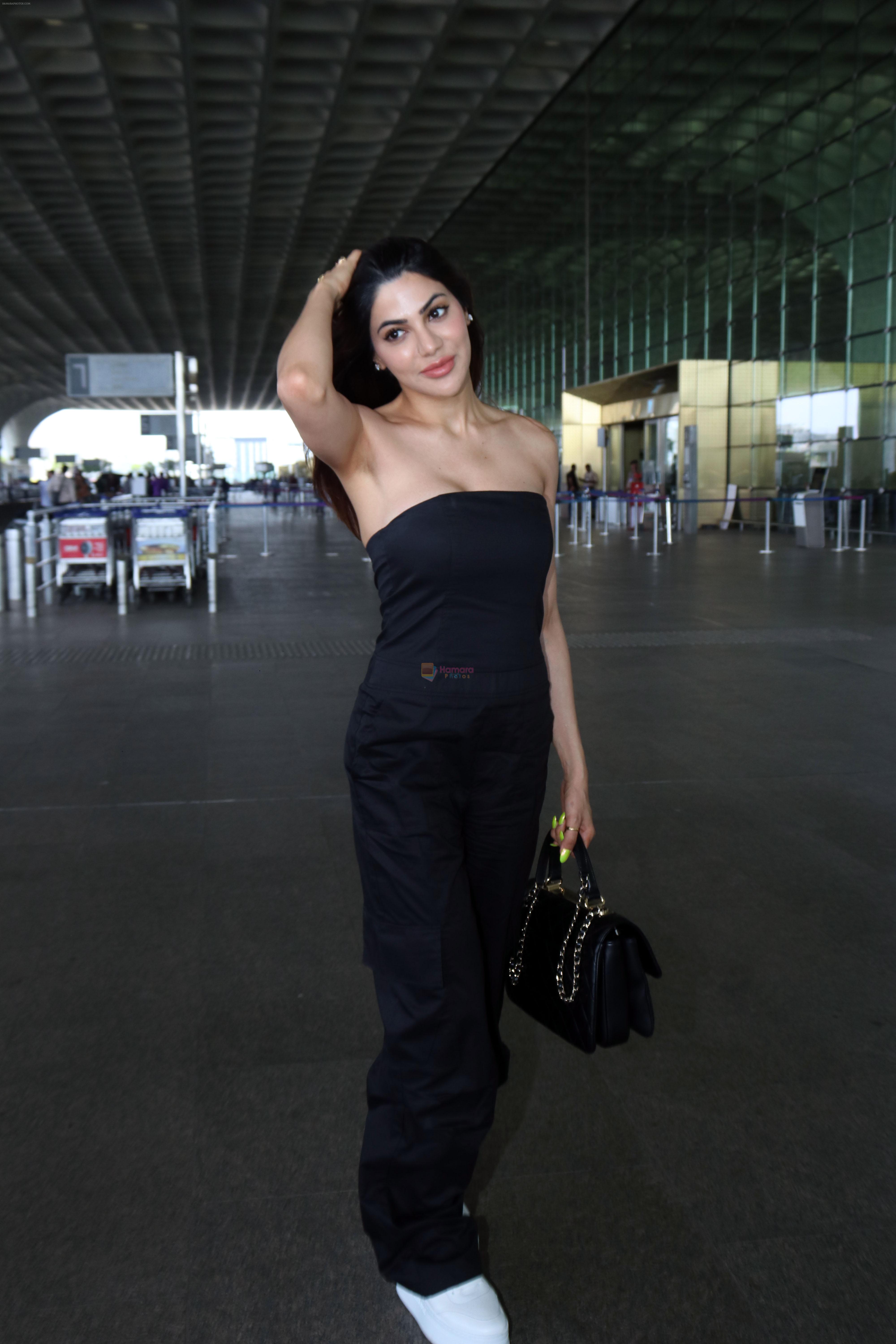 Nikki Tamboli wearing all black strapless bodycon dress, white sneakers holding Tamboli holding Chanel Black Quilted Lambskin Small Trendy Top Handle Flap Bag