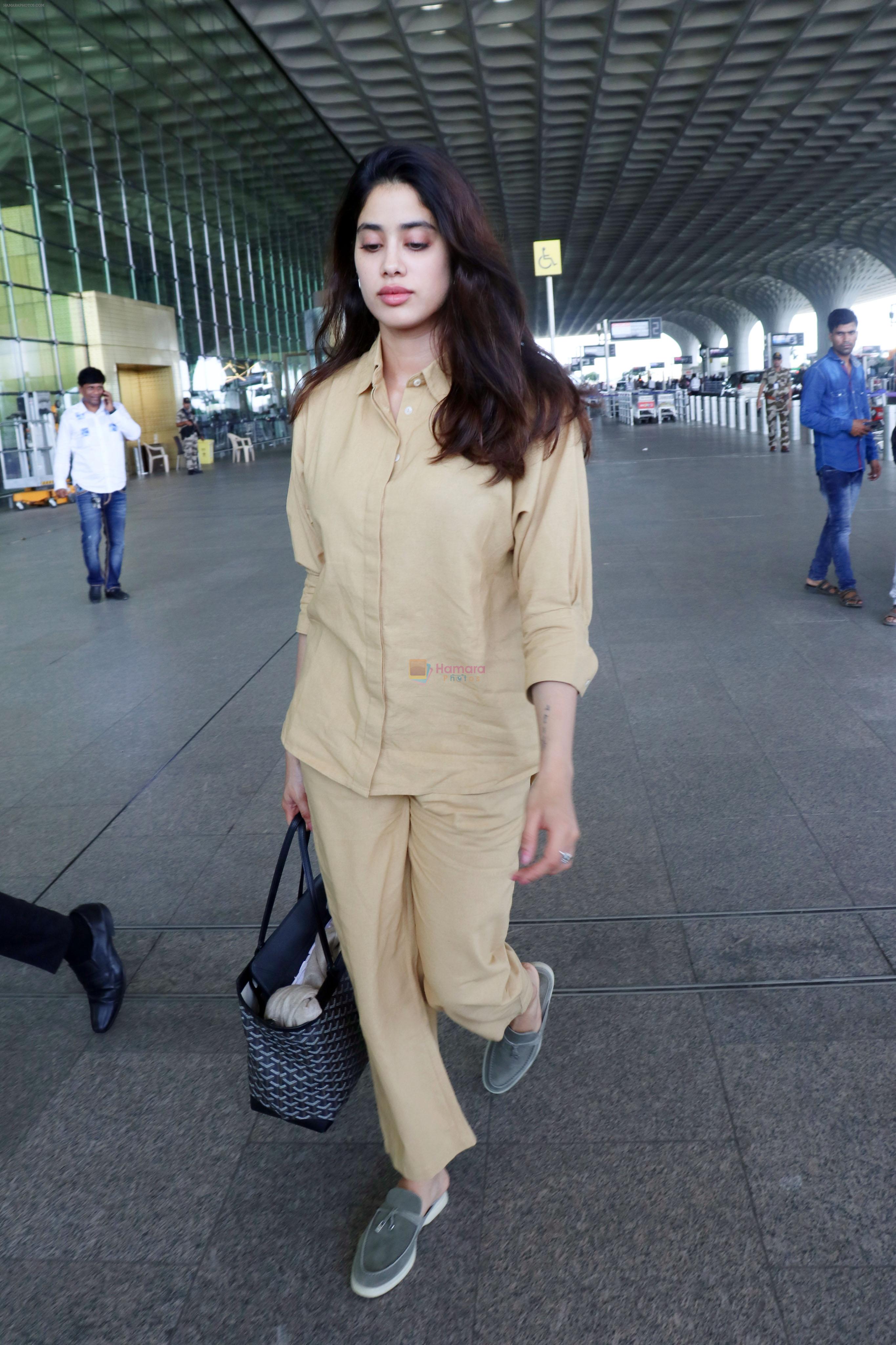 Janhvi Kapoor holding Tas Goyard Saint Louis PM Tote handbag wearing light brown shirt and wide pants and Meya light green genuine suede leather loafer shoes