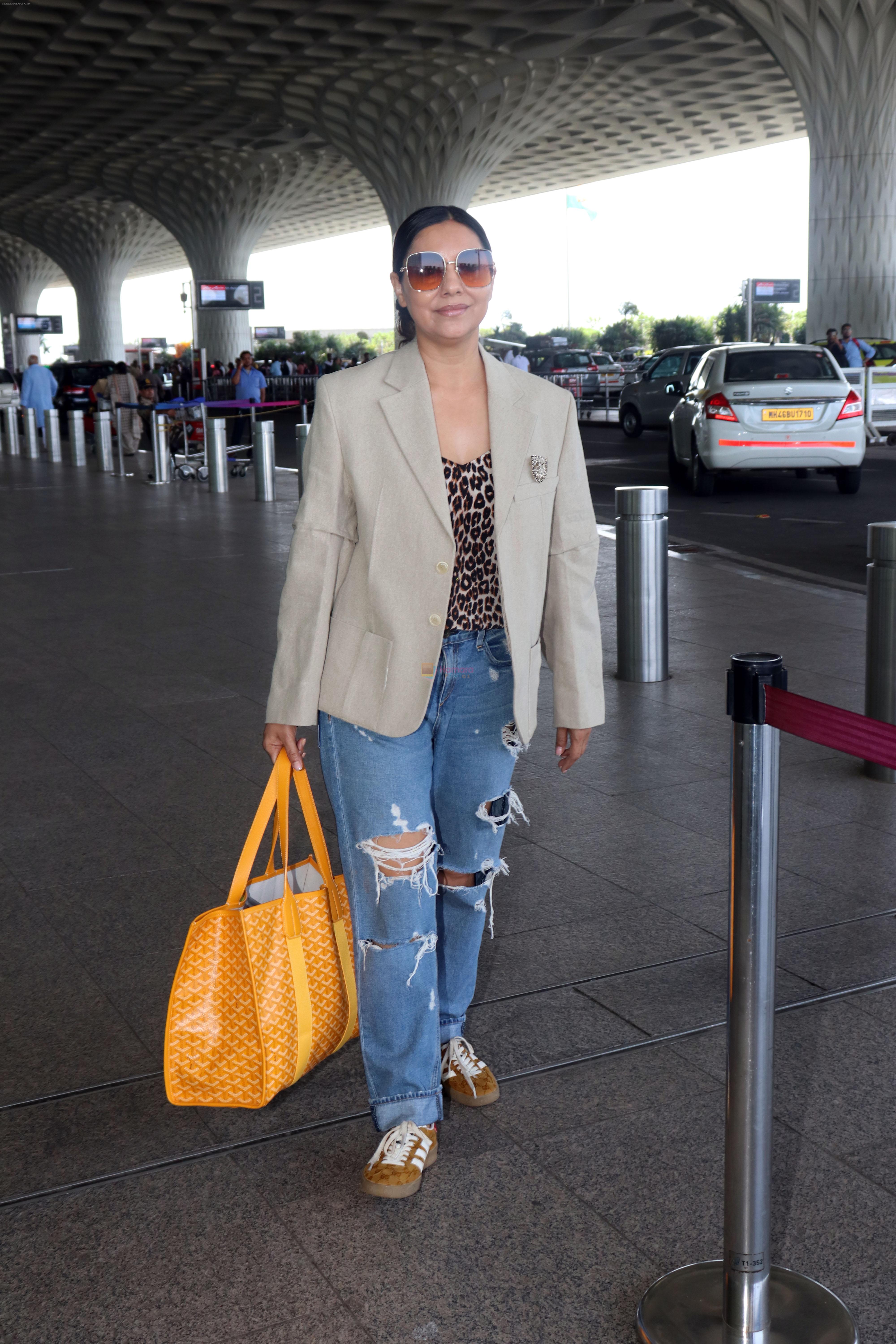 Gauahar Khan holding Villette Tote Bag wearing Gazelle Gucci Mesa White Red shoes, Balmain distressed effect finish jeans, overcoat and sunglasses