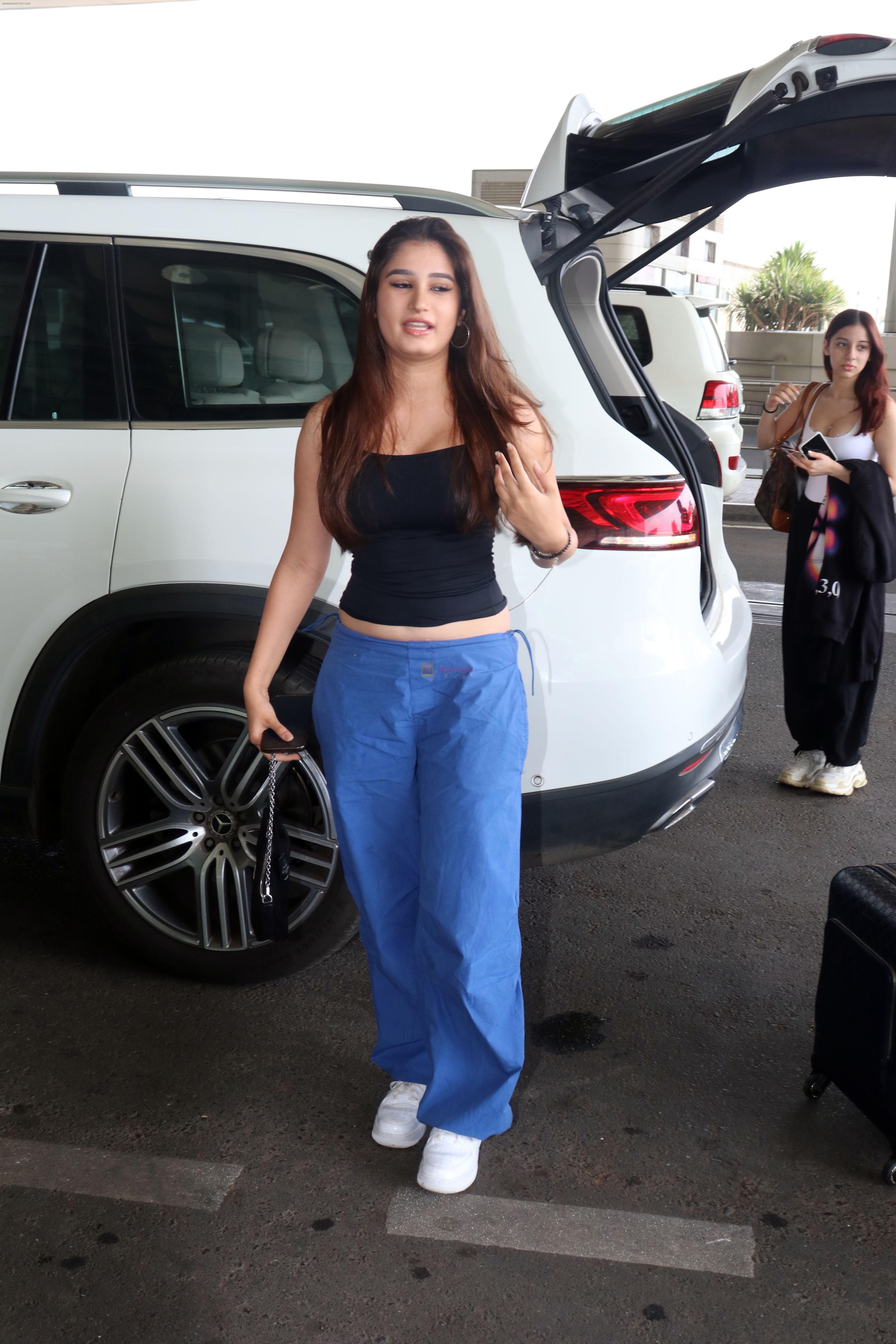 Rasha Thadani dressed in black camisole and blue baggy casual pant, white shoes holding Prada leather shoulder bag