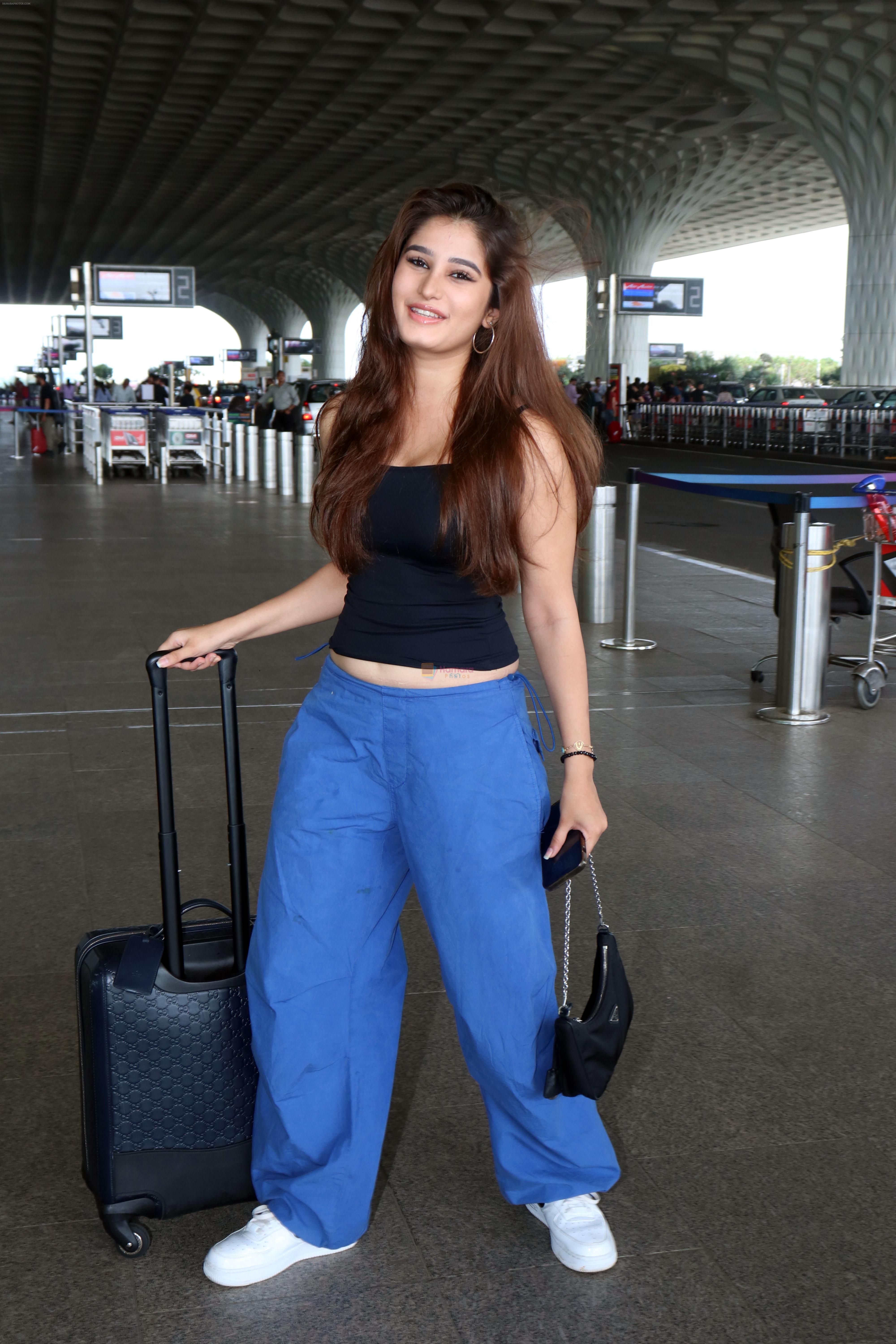 Rasha Thadani dressed in black camisole and blue baggy casual pant, white shoes holding Prada leather shoulder bag