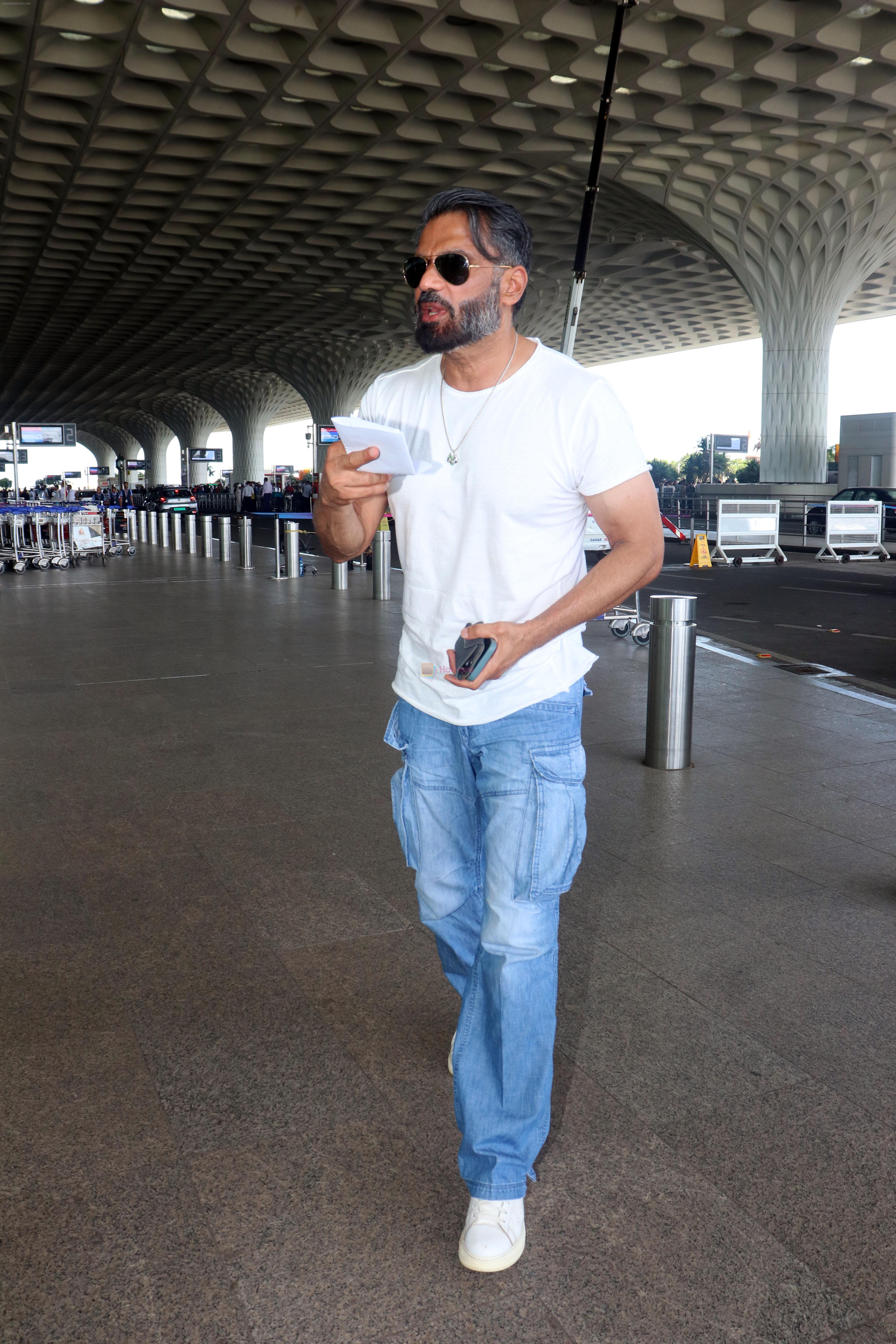 Suniel Shetty wearing white tshirt and baggy blue jeans