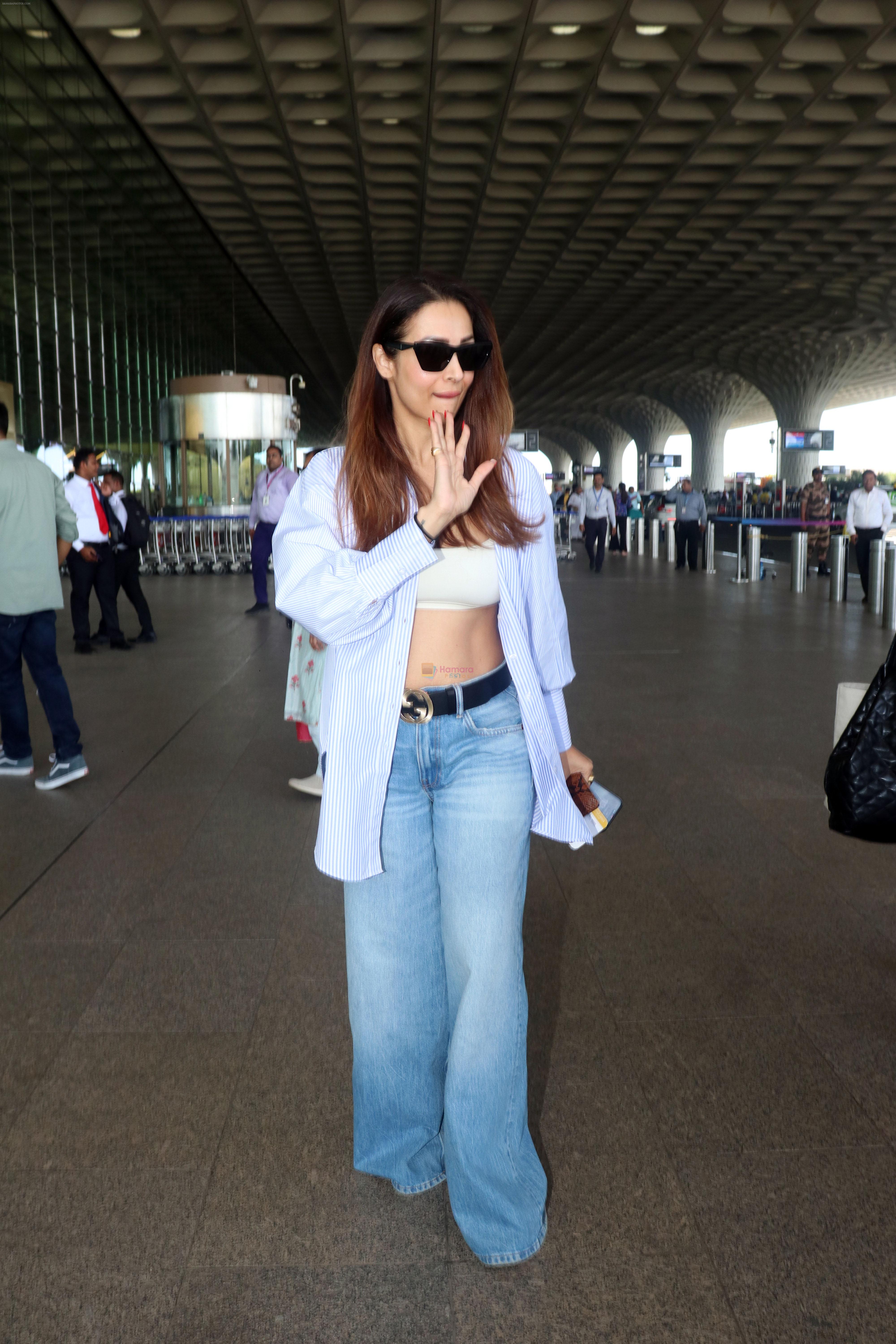 Malaika Arora wearing blue jeans unbuttoned shirt and sunglasses