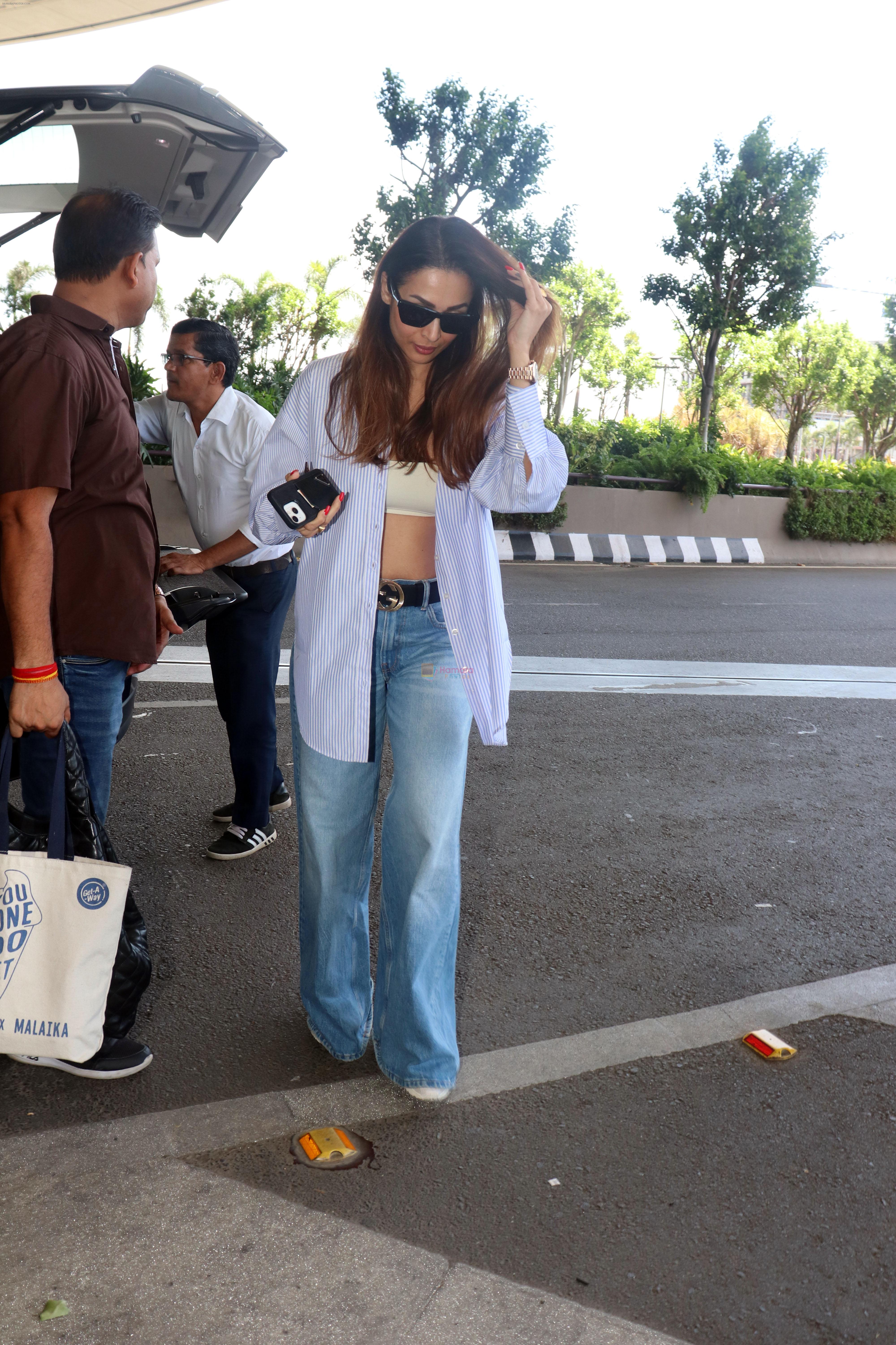 Malaika Arora wearing blue jeans unbuttoned shirt and sunglasses