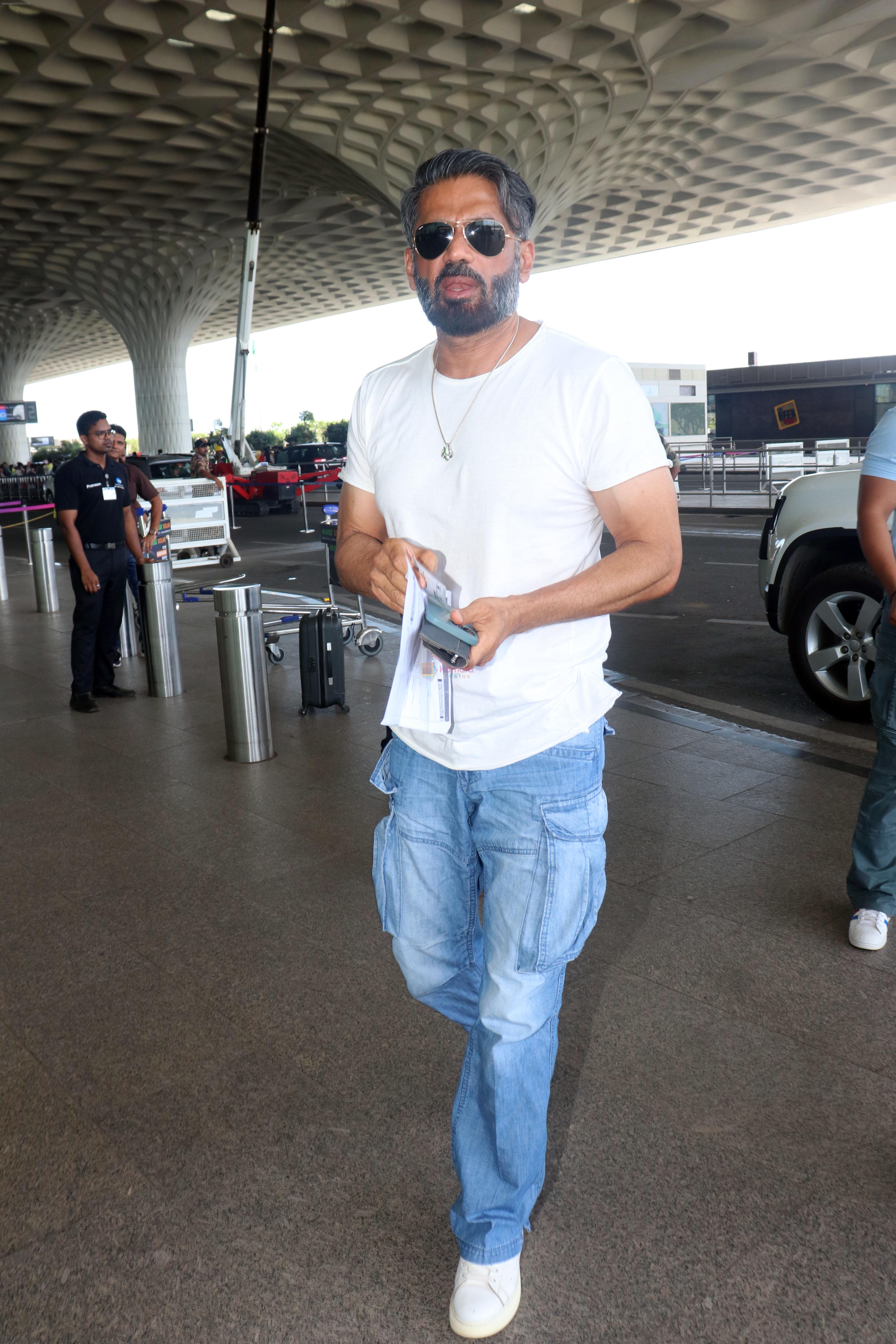 Suniel Shetty wearing white tshirt and baggy blue jeans