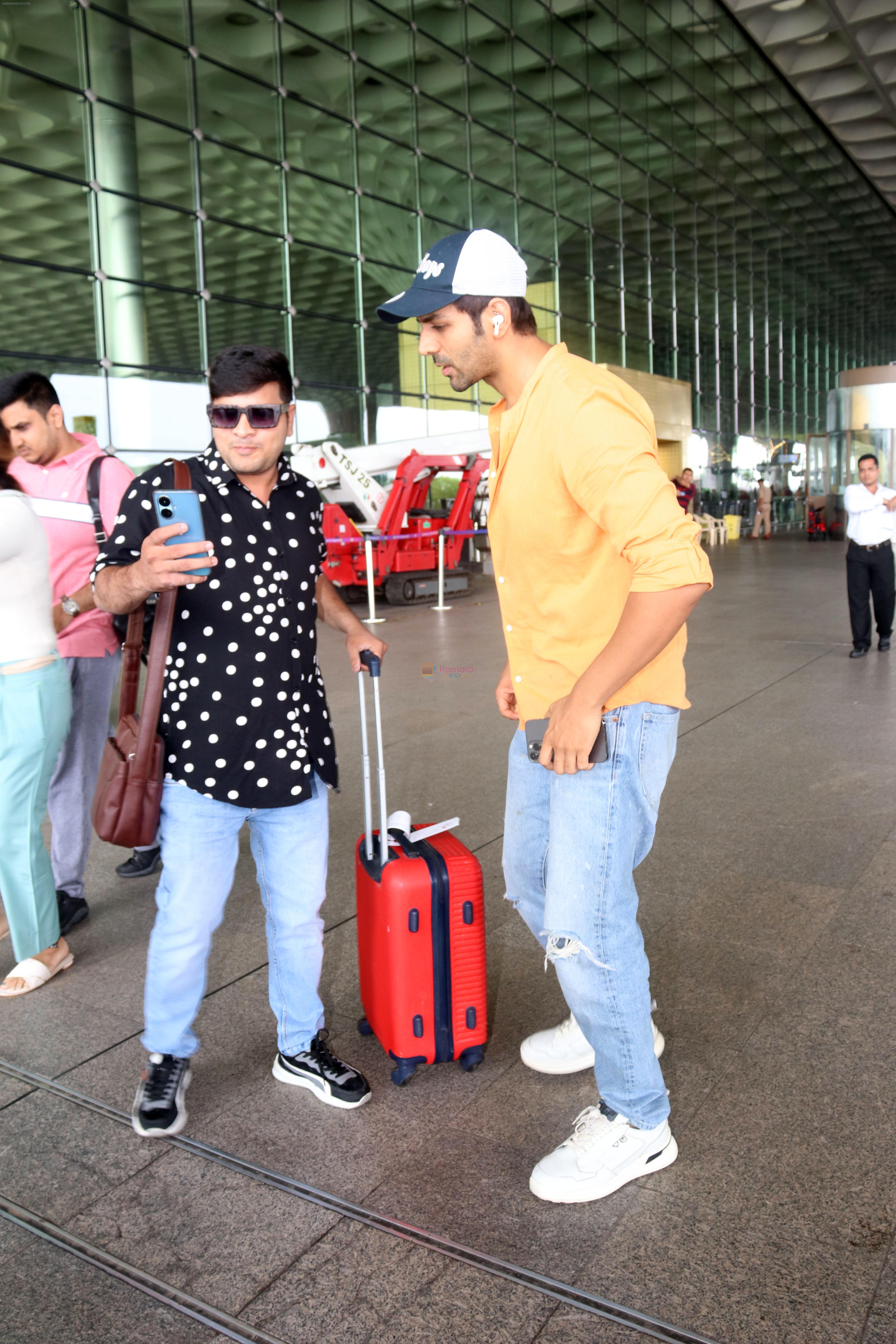 Kartik Aaryan dressed in orange shirt and blue shredded jeans and Dallas Cowboys hat seen at the airport on 25 Jun 2023