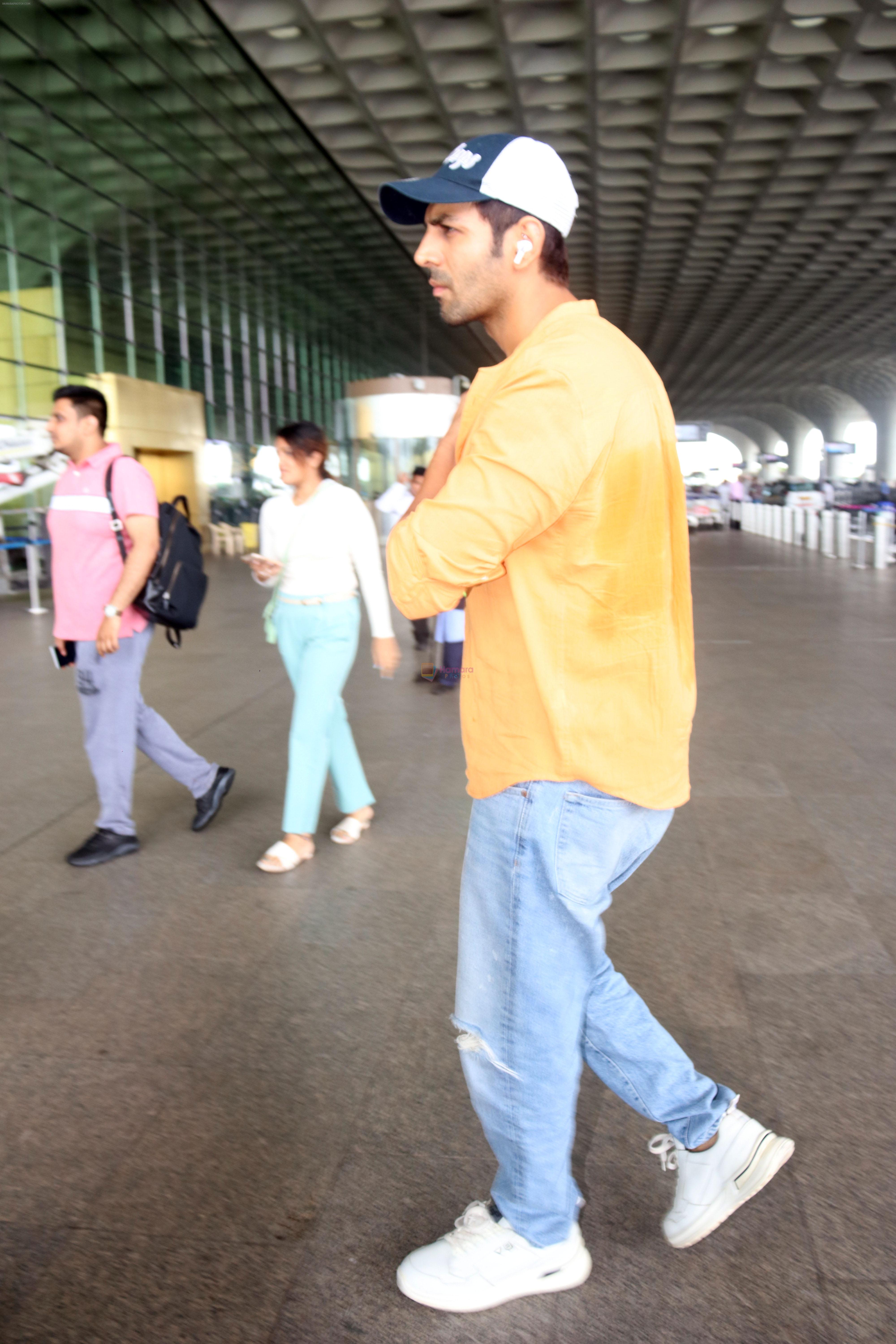 Kartik Aaryan dressed in orange shirt and blue shredded jeans and Dallas Cowboys hat seen at the airport on 25 Jun 2023