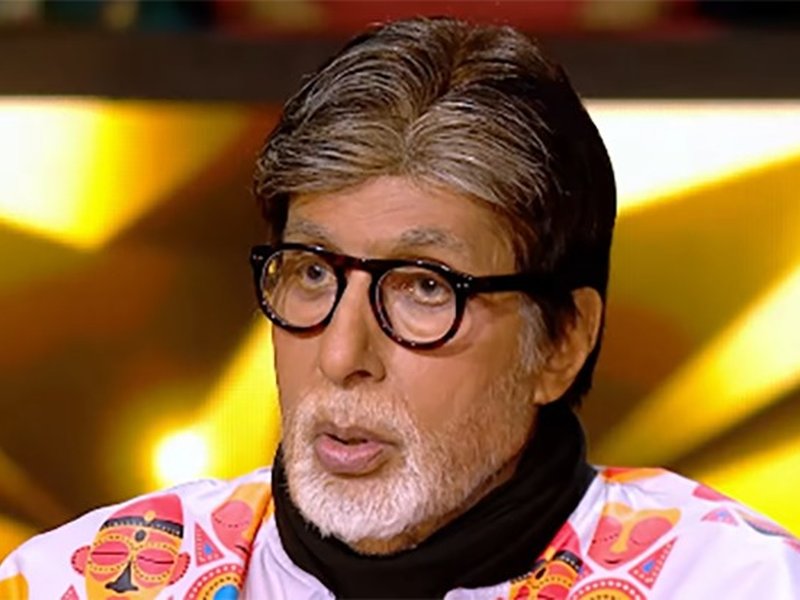 Amitabh Bachchan laughing with KBC contestant Mitkumar Thakrar on hot seat