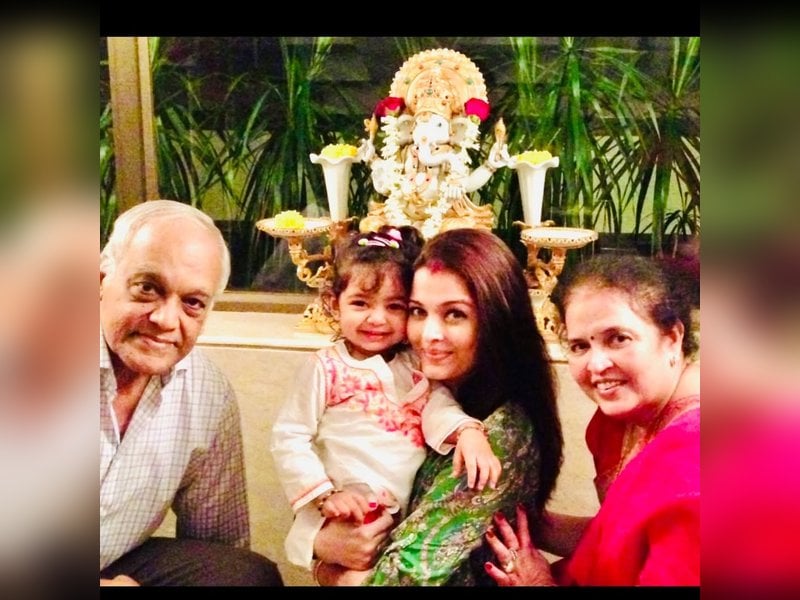 Aishwarya Rai holding smiling Aaradhya Bachchan cuddling with her grandparents on anniversary